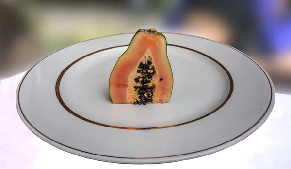 Färsk saftiga halv papaya på en vit platta med guld kant — Stockfoto
