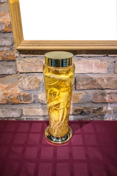 Ginseng kökü ve şifalı tentürle dolu klasik cam şişe.