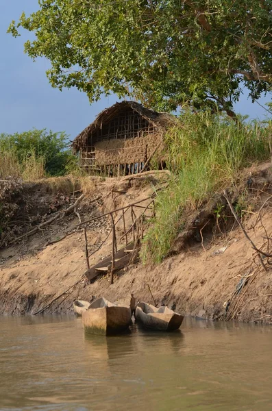 Ahşap Kano ve Tanzanya Afrika'daki Mikumi nehir kıyısında içinde çamur kulübe — Stok fotoğraf