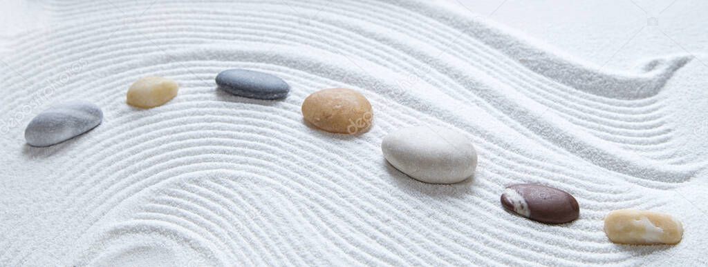 Zen pebbles on white sand pattern