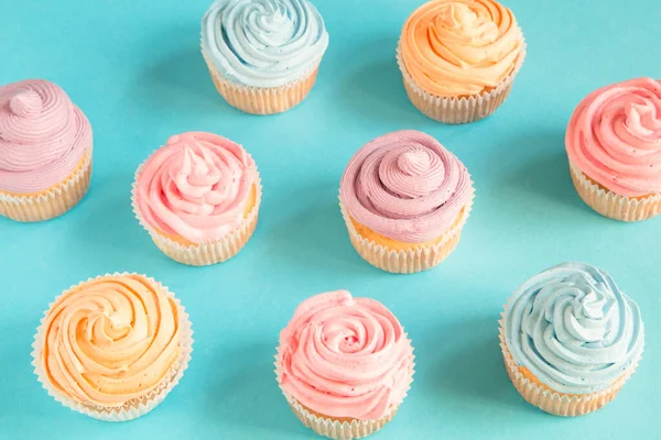 Colorful birthday cupcakes on blue background