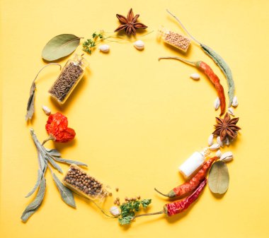 Sarı arka planda bitkiler ve baharatlar dönüyor.