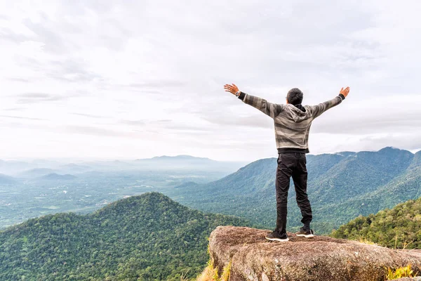 Feliz joven en la cima de la montaña extendiendo la mano y disfrutando de la vista de la montaña valle . —  Fotos de Stock