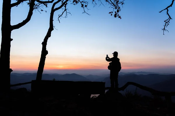 Ponto de vista do rio Mae Ping. Mulher silhueta tirando uma foto do nascer do sol da montanha por telefone celular . — Fotografia de Stock