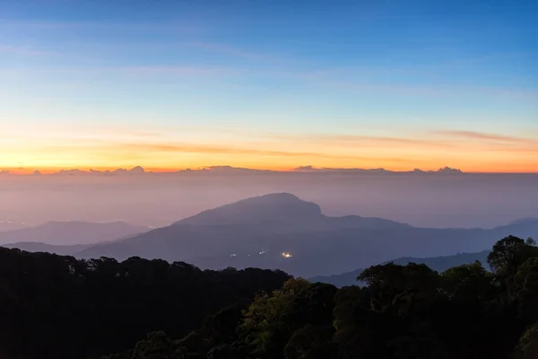 Crepúsculo no céu limpo antes do nascer do sol sobre montanhas escuras na sombra no Doi Inthanon National Park. Chiang Mai, Tailândia . — Fotografia de Stock