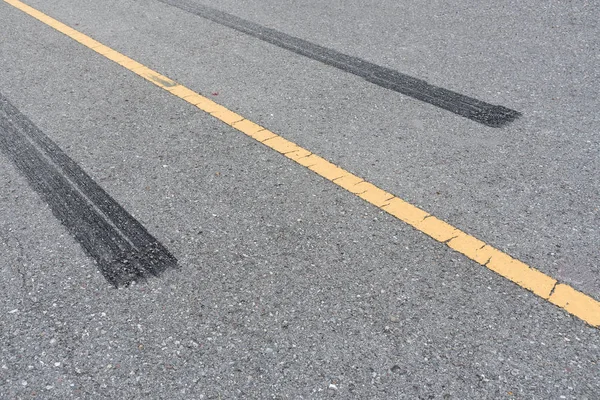 Renkaanjäljet, pyörän jälki asfalttitiellä . — kuvapankkivalokuva