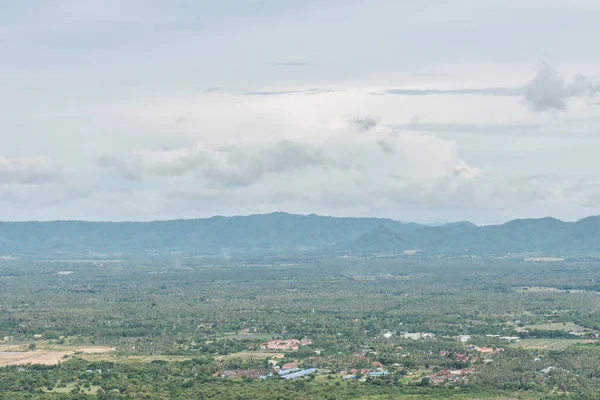 Dağ ve bulutlu gökyüzü arka plan üzerinde kırsal alan.