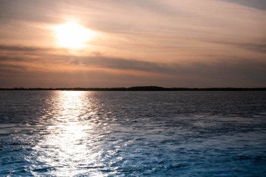 Düşük turuncu gün batımı dramatik bulutlar üzerinde nehir