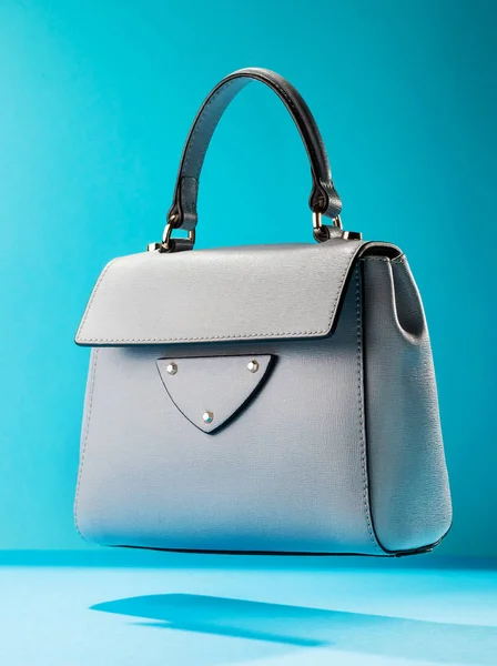 Stylish leather women\'s handbag on a blue background