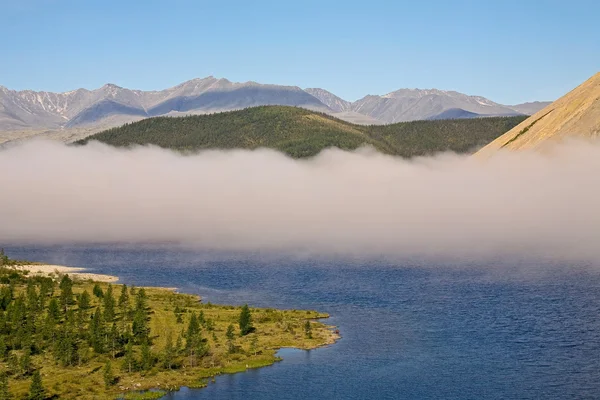 Eine Nebelwolke über einem Bergsee. — Stockfoto
