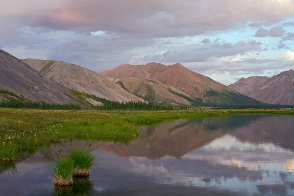 Montañas en la luz del atardecer y reflejos en el lago . —  Fotos de Stock