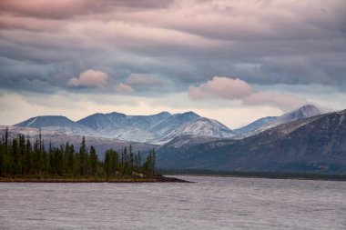 Bulutlar dağlar ve büyük göl üzerinde.