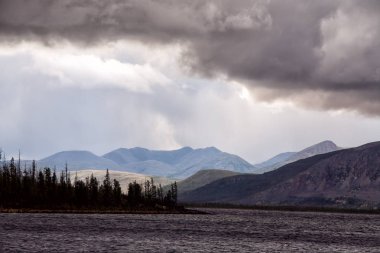 Bulutlar dağlar ve büyük göl üzerinde. 