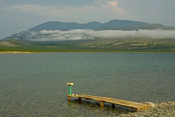 Ein kleiner Steg am Ufer eines Bergsees. — Stockfoto