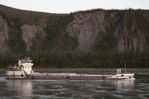 Yakıt bir dağ nehir üzerinde taşıyan gemi.