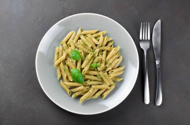 Bir gri ev yapımı pesto soslu kepekli makarna plaka üzerinde bir