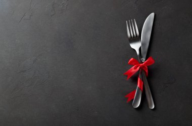 Çatal bıçak ve çatal kırmızı saten yay, karanlık s ile şenlikli kümesi