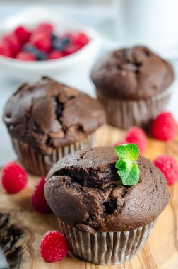 Taze ahududu ile ahşap bir tahtada üç çikolatalı kek