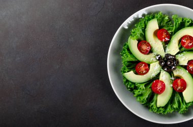 Kiraz domates, zeytin, salata yaprakları ve ch dilimlenmiş avokado