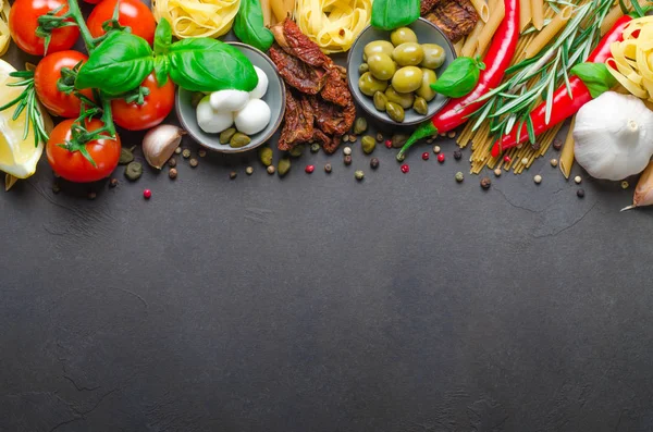 Italian food on a dark background with copy space, ingredients f