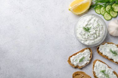 Ev yapımı Yunan tzatziki sos malzemelerle bir cam kabın içinde bir
