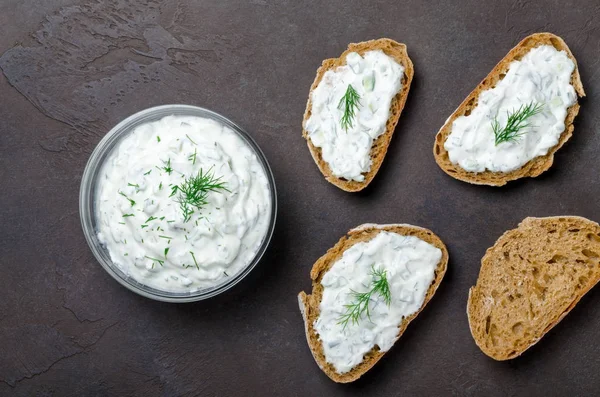 Molho tzatziki grego caseiro em uma tigela de vidro com pão fatiado — Fotografia de Stock