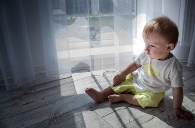 Şirin Bebek evde beyaz oda pencere oturuyor. Güzel bebek bir erkek ya da kız olabilir ve beden takım elbise giyiyor. Bebeğin kıvırcık ile duydum kameraya arıyor.