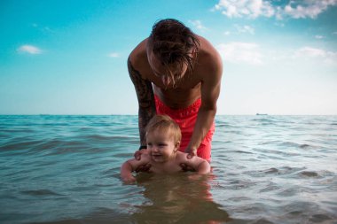 Baba ve bebek oğlum deniz suda oynamak