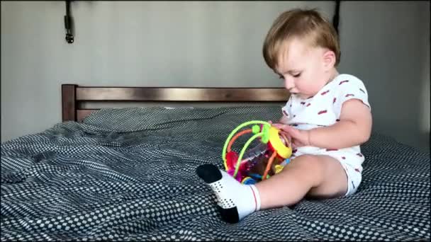 Niño jugando en la cama con juguete — Vídeos de Stock