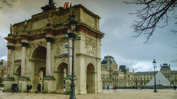 巴黎-八月︰ 游客行人附近弧 de 凯旋门杜卡鲁塞尔，它是一个凯旋门，建成于 1806 年，为纪念拿破仑的军事胜利, — 图库照片
