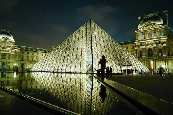 Parijs - 11 mei: Toeristen lopen voor het Louvre, Parijs, Frankrijk, 11 mei 2016. Het Louvre is de meest bezochte kunstmuseum in de wereld en een historisch monument. — Stockfoto