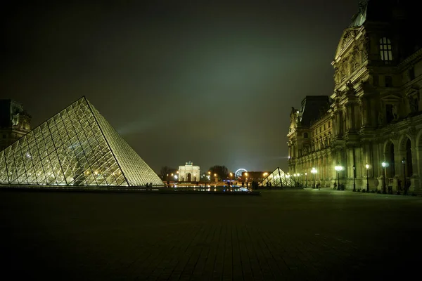 Parijs - 11 mei: Toeristen lopen voor het Louvre, Parijs, Frankrijk, 11 mei 2016. Het Louvre is de meest bezochte kunstmuseum in de wereld en een historisch monument. — Stockfoto