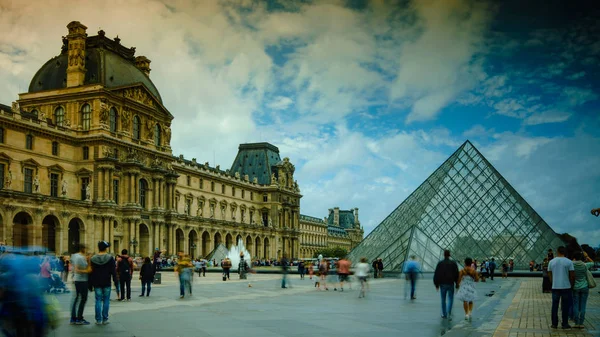 Paris - maj 11: Turister vandrar framför Louvren, 11 maj 2016 i Paris. Louvren är det mest besökta konstmuseet i världen och ett historiskt monument. — Stockfoto