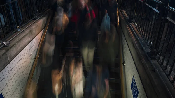 LONDRES, Reino Unido, DICIEMBRE, La estación de metro en Oxford Circus se inunda todos los días con los viajeros en su camino a casa después del trabajo, la entrada de la estación lucha para hacer frente al volumen de personas. larga exposición — Foto de Stock