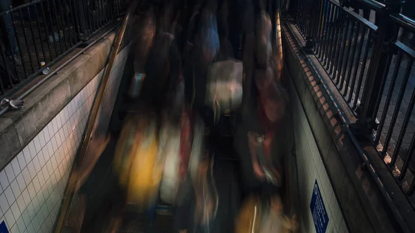 LONDRES, Reino Unido, DICIEMBRE, La estación de metro en Oxford Circus se inunda todos los días con los viajeros en su camino a casa después del trabajo, la entrada de la estación lucha para hacer frente al volumen de personas. larga exposición — Foto de Stock