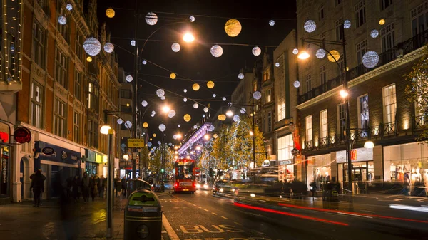 London - DECEMBER: Christmas lights and London buses at the station on busy Oxford Street London, England, United Kingdom in December. Oxford circus at traffic rush. — Stock Photo, Image