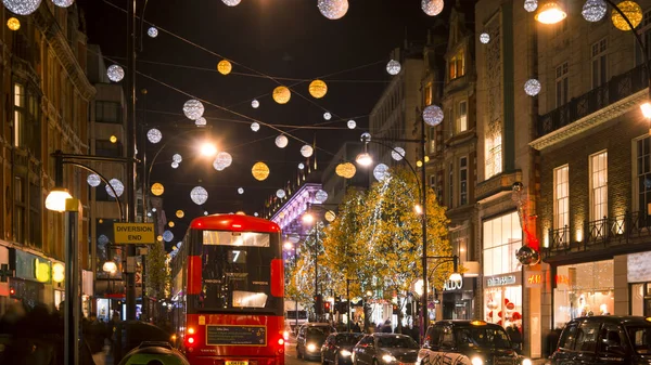 London - DECEMBER: Christmas lights and London buses at the station on busy Oxford Street London, England, United Kingdom in December. Oxford circus at traffic rush. — Stock Photo, Image