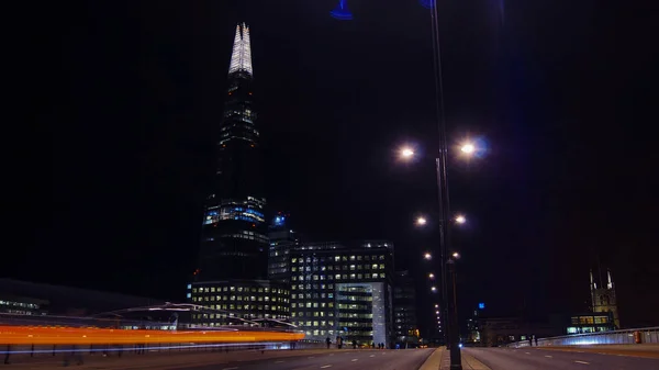 Coches de tráfico y peatones en el Puente de Londres en la noche con The Shard en segundo plano, larga exposición — Foto de Stock