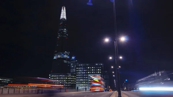 Verkeer-auto's en voetgangers op London Bridge in de nacht met The Shard in achtergrond, lange blootstelling — Stockfoto