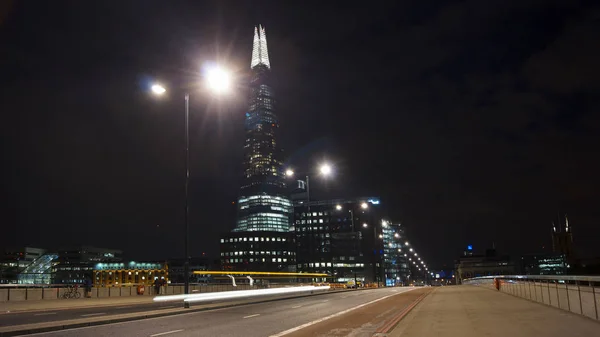 London, Egyesült Királyság - április 5-én: Forgalom autók és gyalogosok-a London Bridge-az éjszaka a Szilánk a háttérben április-ben London, Egyesült Királyság. hosszú expozíció, közlekedési lámpa — Stock Fotó