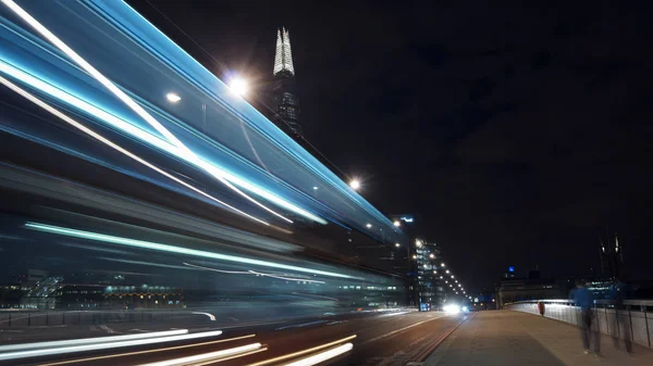 LONDON, UK - APRIL 5: Traffic cars and pedestrians on London Bridge in the night with The Shard in background on April in London, UK. long exposure, traffic light — Stock Photo, Image