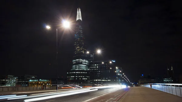 London, Verenigd Koninkrijk - 5 April: Verkeer auto's en voetgangers op London Bridge in de nacht met The Shard in achtergrond op April in Londen, Verenigd Koninkrijk. lange blootstelling, verkeerslicht — Stockfoto