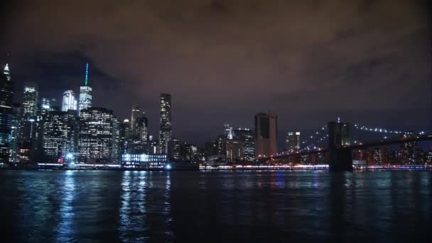 New York City városkép felhőkarcolók skyline éjszaka híd East River view Manhattan víz elmélkedés Usa keleti partján, kerület panoráma kilátás forgalom areal nézet nagy város, Időközű, 4k — Stock videók