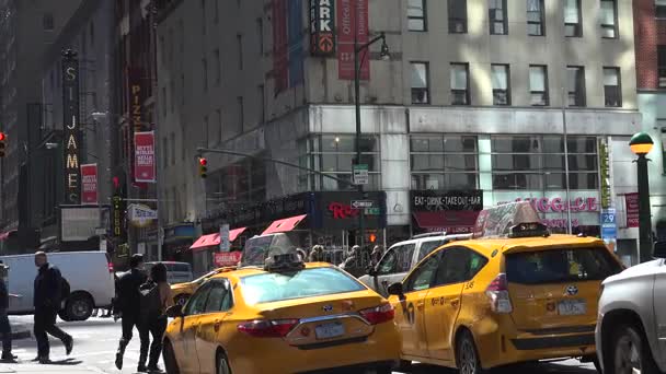 New York-circa 2017: tráfego pesado nas ruas estreitas de Manhattan, com alturas impressionantes de blocos e publicidade brilhante à tarde, em um dia ensolarado, ultra hd4k, em tempo real — Vídeo de Stock