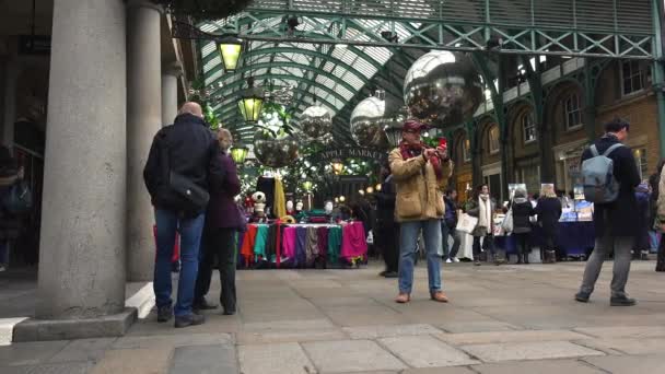 Londýn, Velká Británie - cca 2016: vánoční ozdoby v Covent Garden market, pohled Apple trh v Covent Garden. Je trh Apple prodává umění a řemesla věnované starožitnosti a sběratelské předměty. — Stock video