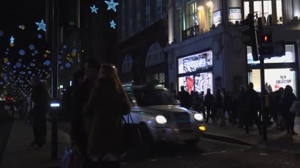 Лондон - Dec 2016: Різдвяні вогні і Лондонські автобуси на станції на зайнятий Лондоні вулиці Оксфорд, Англія, Сполучене Королівство, у грудні, 2016. Оксфордської площі в пік трафіку. — стокове відео