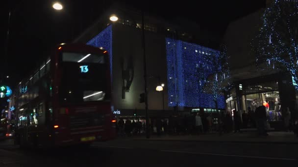 London - DEC 2016: Christmas lights and London buses at the station on busy Oxford Street London, England, United Kingdom in December, 2016. Oxford circus at traffic rush. — Stock Video