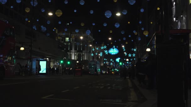 London - DEC 2016: Christmas lights and London buses at the station on busy Oxford Street London, England, United Kingdom in December, 2016. Oxford circus at traffic rush. — Stock Video