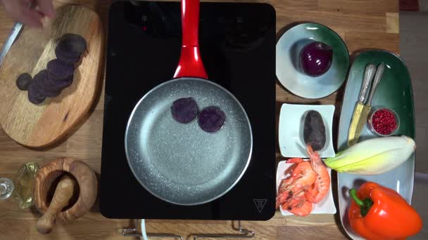 トップ ビュー調理エビと誘導のストーブの上パン紫ジャガイモ — ストック動画