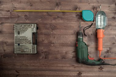 Elektrikli matkap, mezura, twist bit ve bir ahşap lamba 